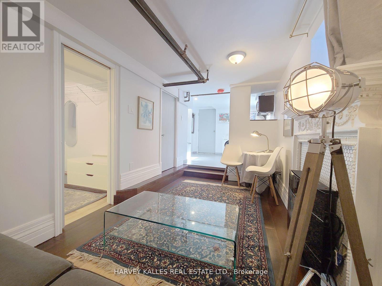 A room with a glass table and a rug in front of it.