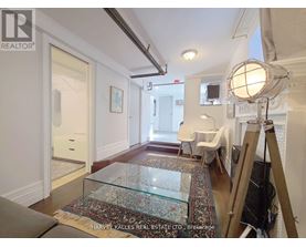 A room with a glass table and a rug in front of it.