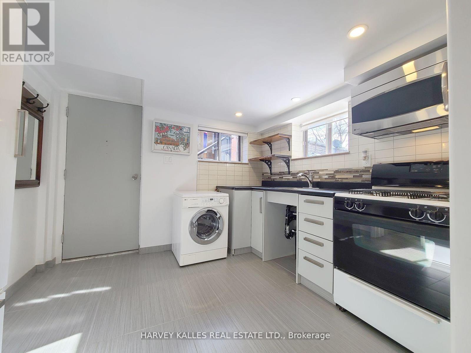 A white kitchen with a washing machine and a fridge.