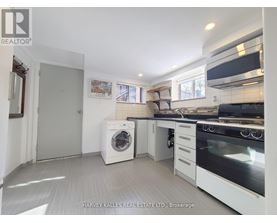 A white kitchen with a washing machine and a fridge.