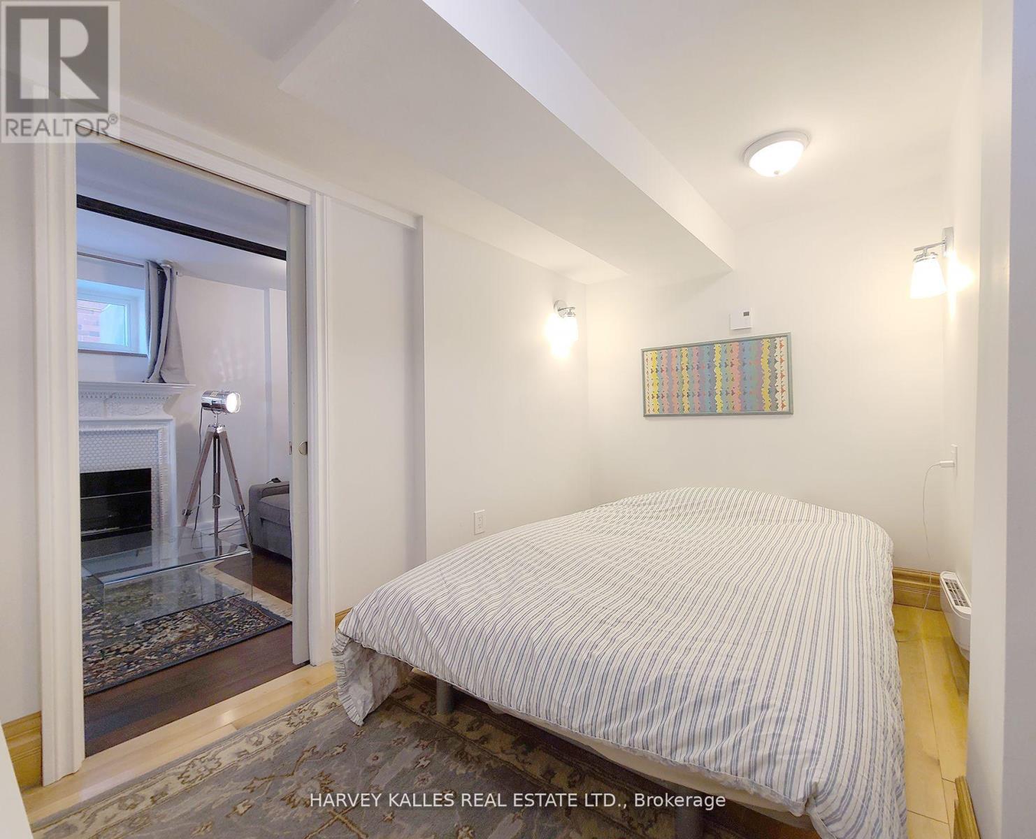 A bedroom with a bed, a window, and a rug.