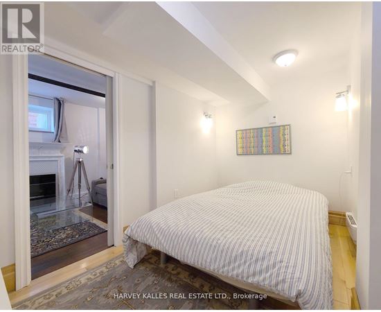 A bedroom with a bed, a window, and a rug.