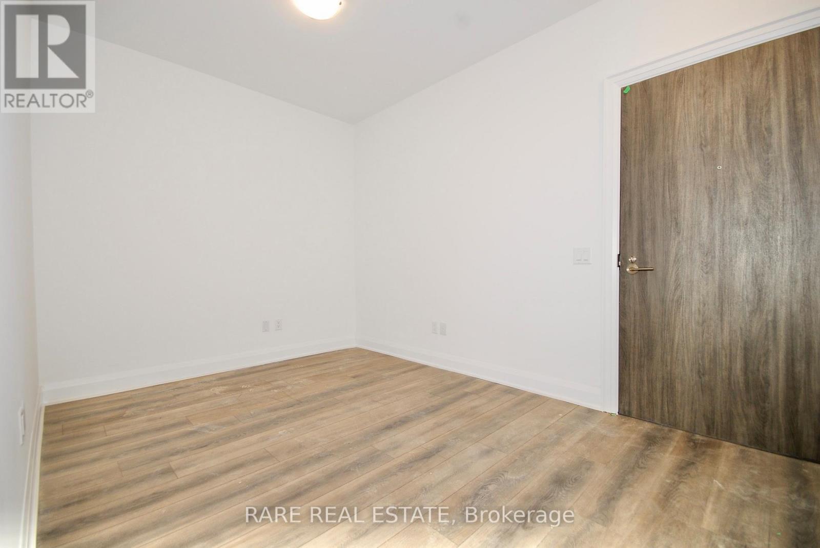 A room with a wooden floor and a wooden door.