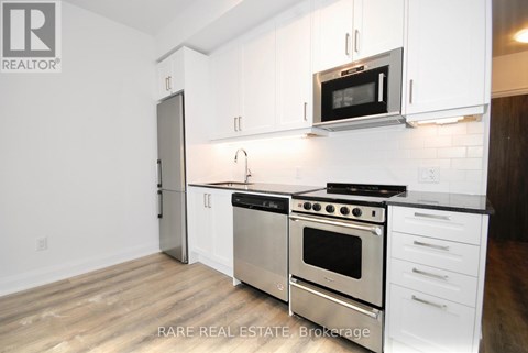 A kitchen with white cabinets and stainless steel appliances.