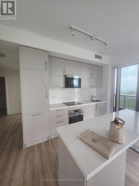 A kitchen with white cabinets and a white counter top.