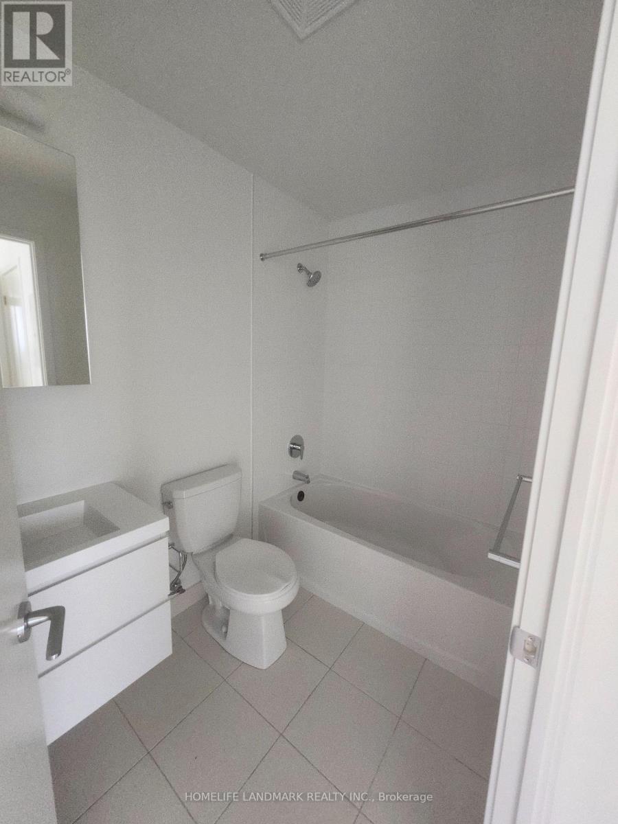 A white bathroom with a toilet, sink, and bathtub.