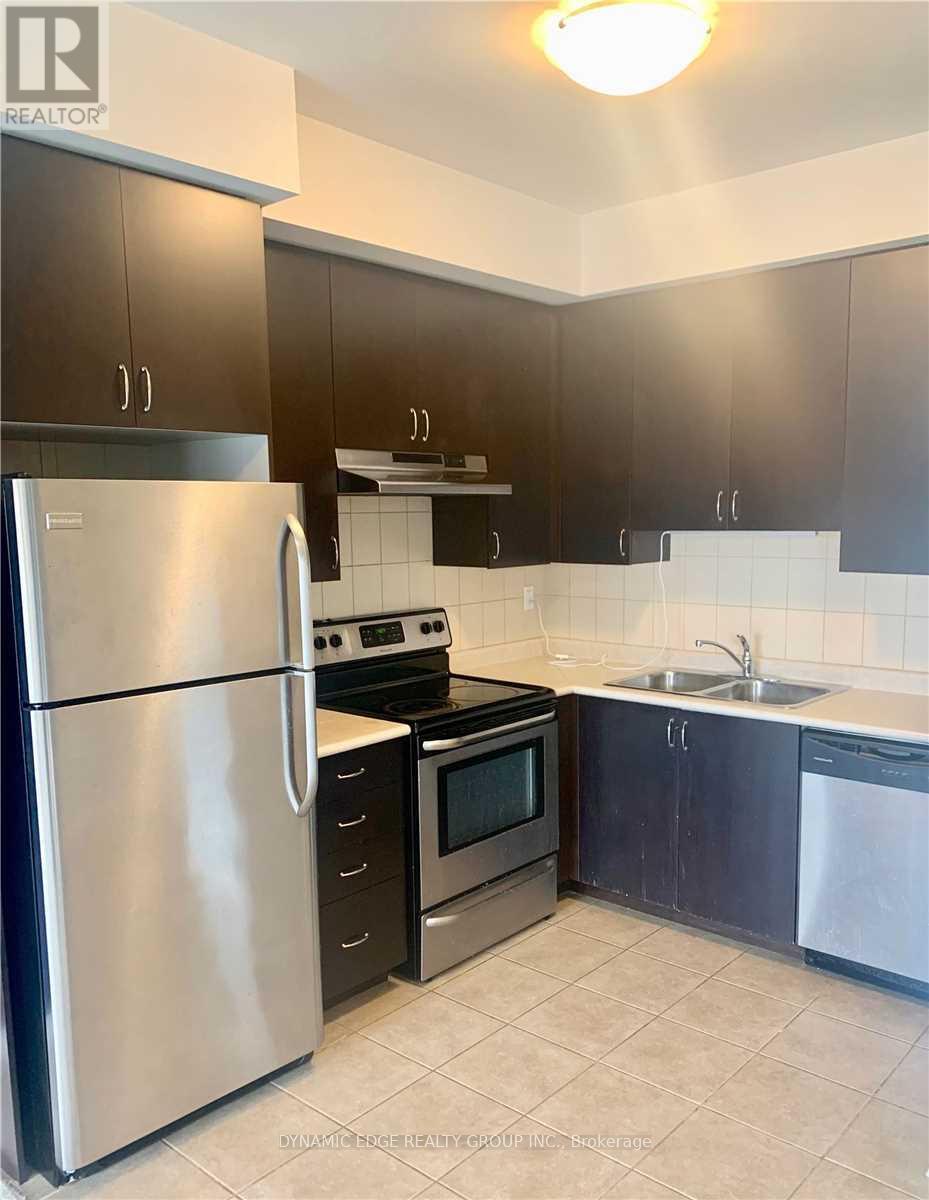 A kitchen with a stainless steel refrigerator, oven, and microwave.
