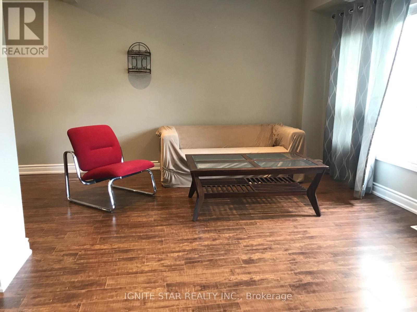 A living room with a red chair, a sofa, and a coffee table.
