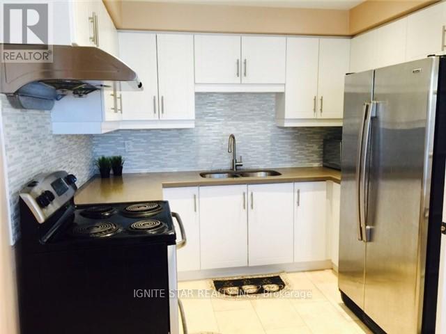 A kitchen with white cabinets and a black stove top.