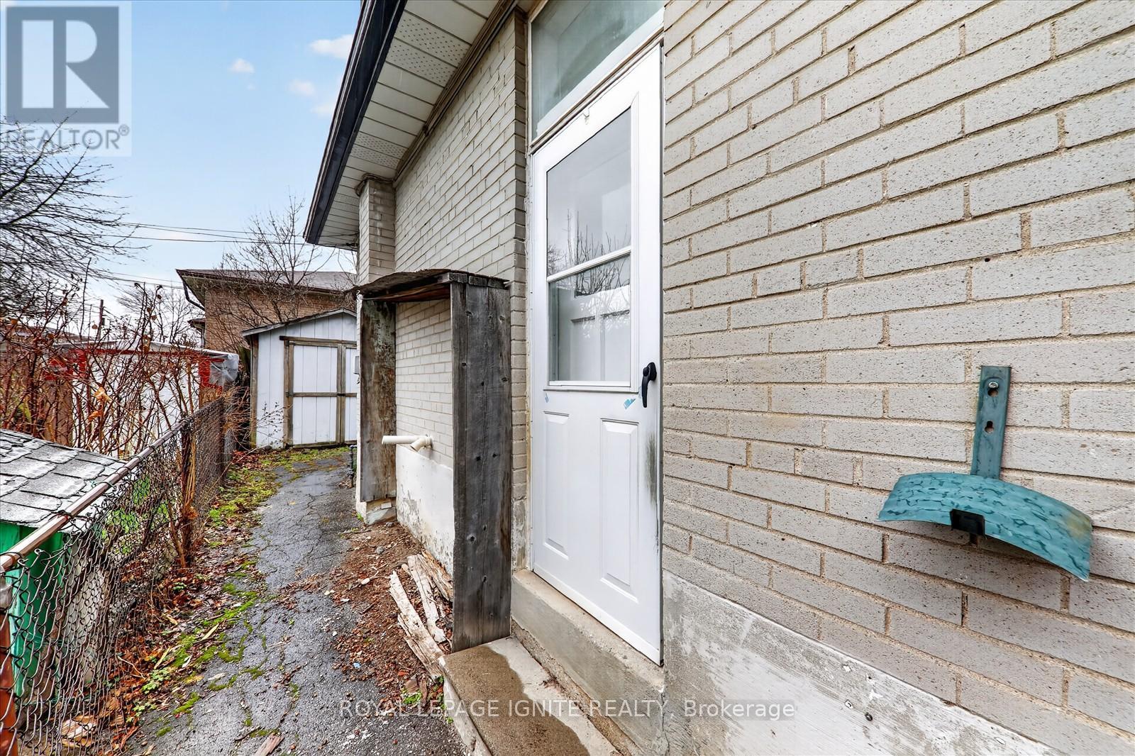 A white door is on the side of a brick building.