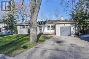 A house with a driveway and a tree in front.