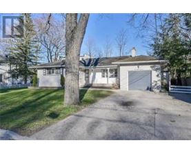 A house with a driveway and a tree in front.