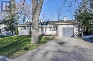 A house with a driveway and a tree in front.