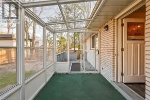 A sunny day at the beach house with a glass roof and a green pool.