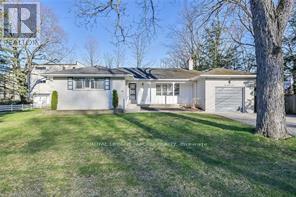 A house with a white exterior and a green lawn in front.