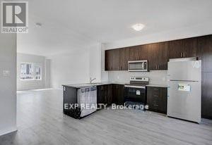 A kitchen with a refrigerator, microwave, and oven.