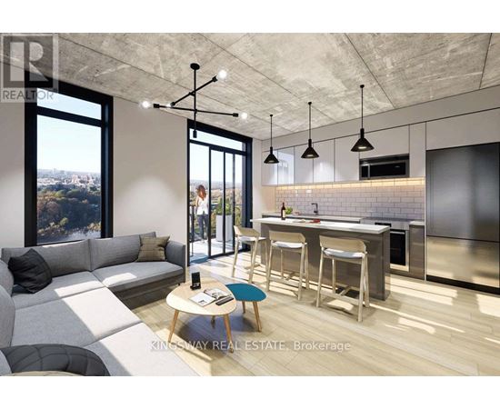 A modern kitchen with a bar stool and a table with a phone on it.