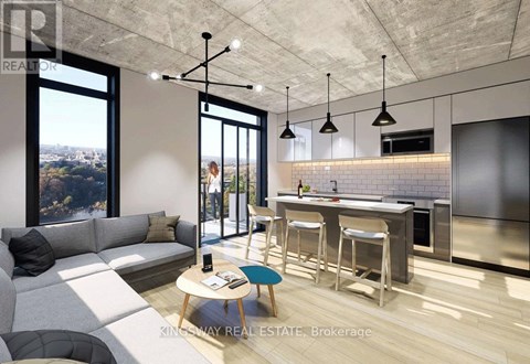 A modern kitchen with a bar stool and a table with a phone on it.