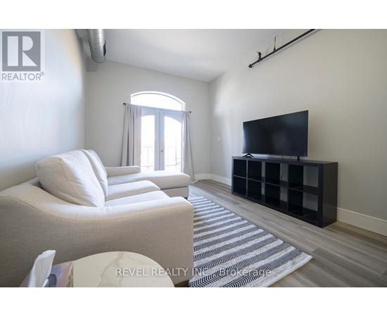 A living room with a white sofa and a black television.