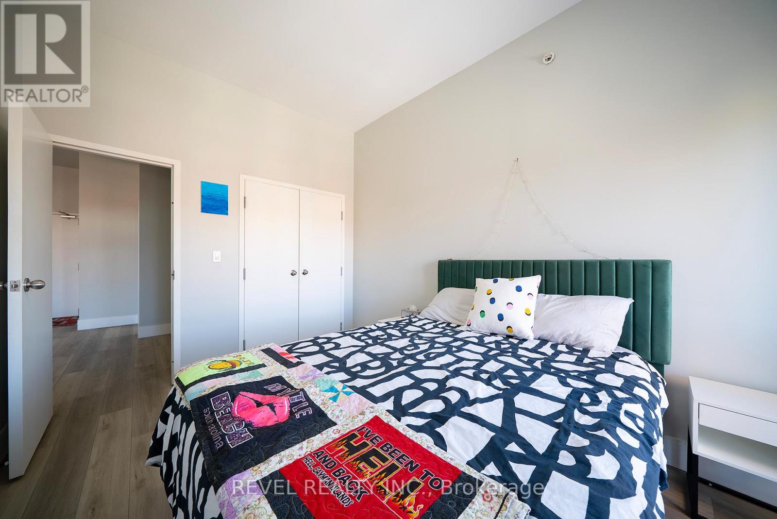 A bedroom with a bed covered in a quilt with many different words on it.