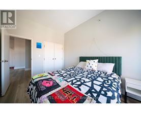 A bedroom with a bed covered in a quilt with many different words on it.