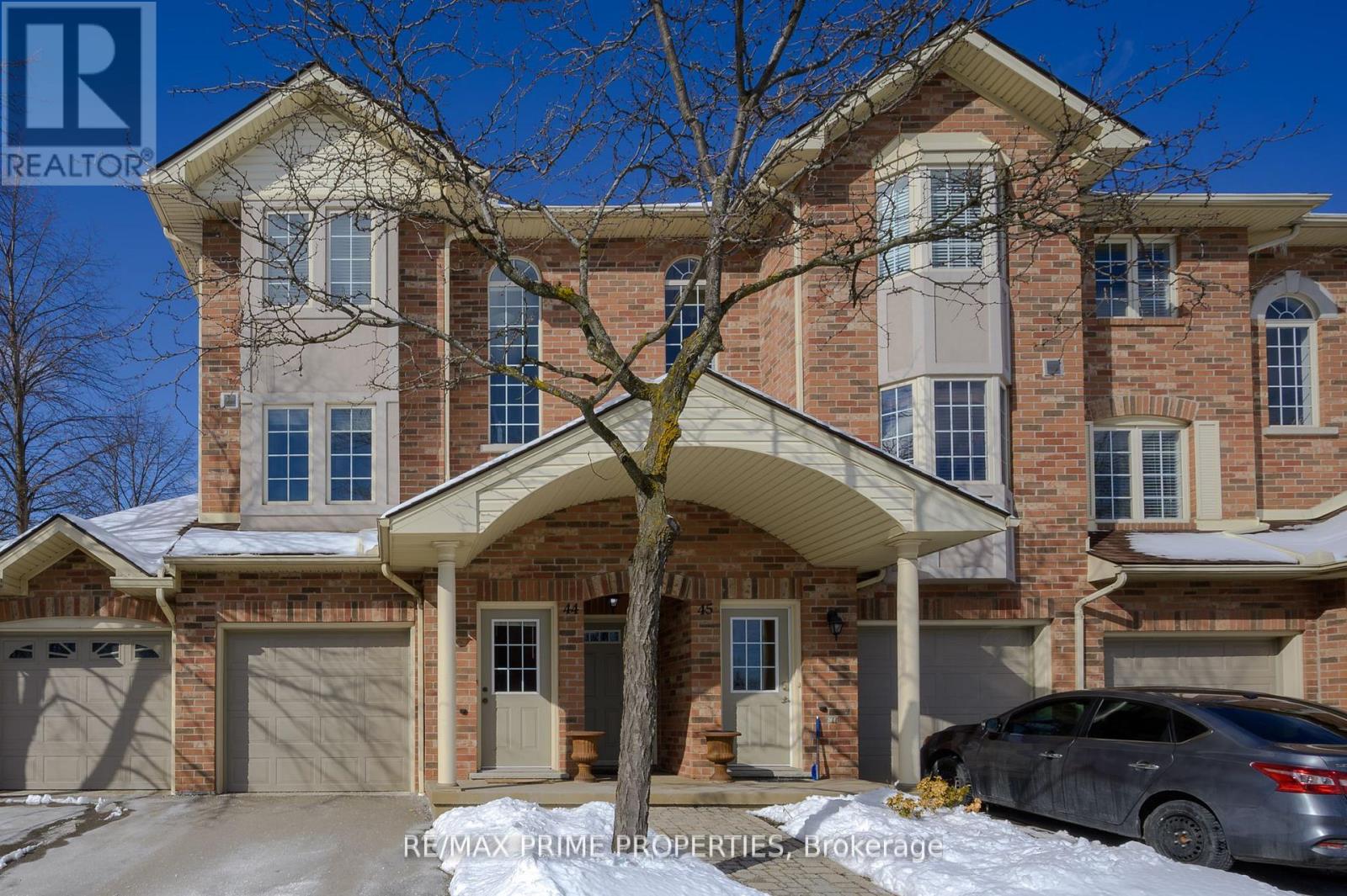 A large, multi-level house with a car parked in front.