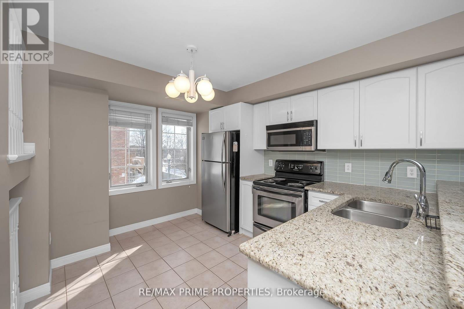 A kitchen with a granite counter top and stainless steel appliances.