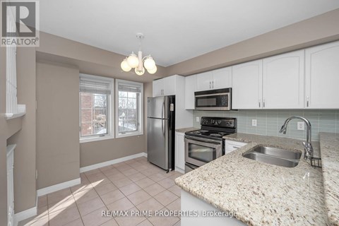A kitchen with a granite counter top and stainless steel appliances.