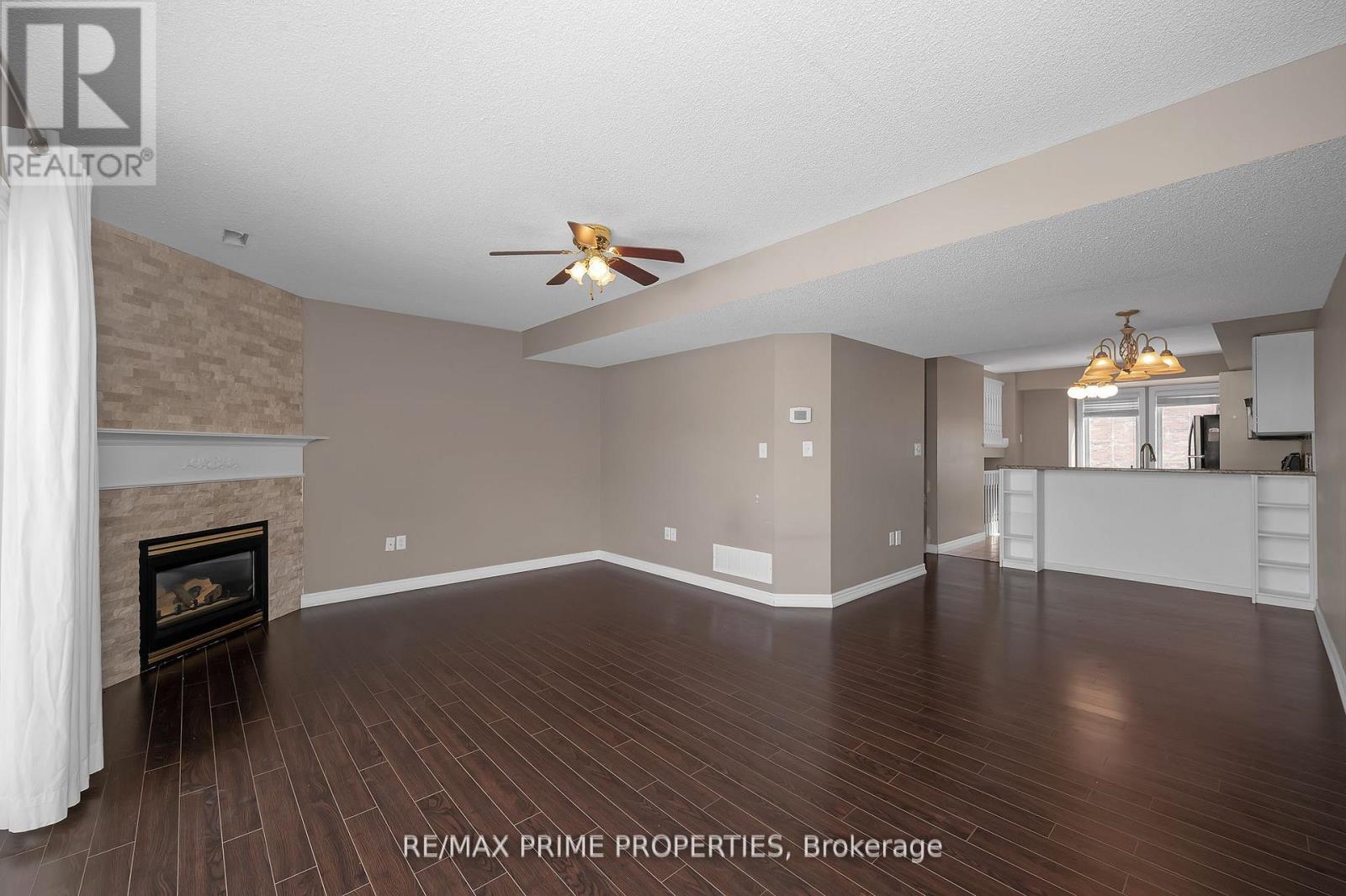 A spacious living room with a fireplace and hardwood floors.
