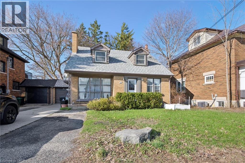 A house with a driveway and a stone in the front yard.