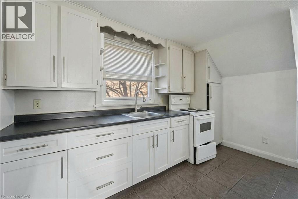 A kitchen with white cabinets and a black countertop.