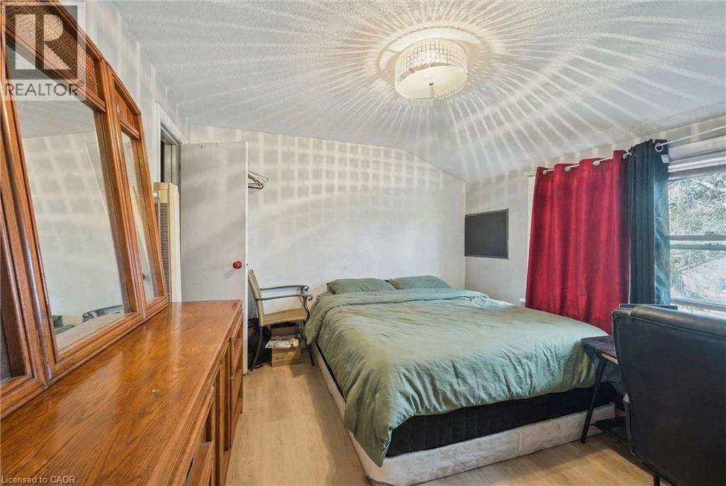 A bedroom with a bed, nightstand, and window.