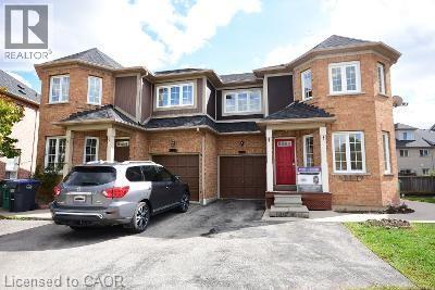 A house with a red door and a silver car parked in front.