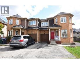 A house with a red door and a silver car parked in front.