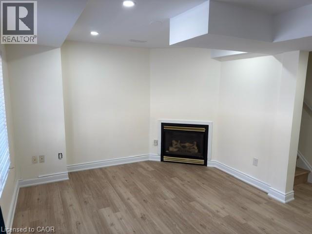A living room with a fireplace and wood flooring.
