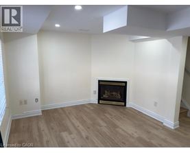 A living room with a fireplace and wood flooring.