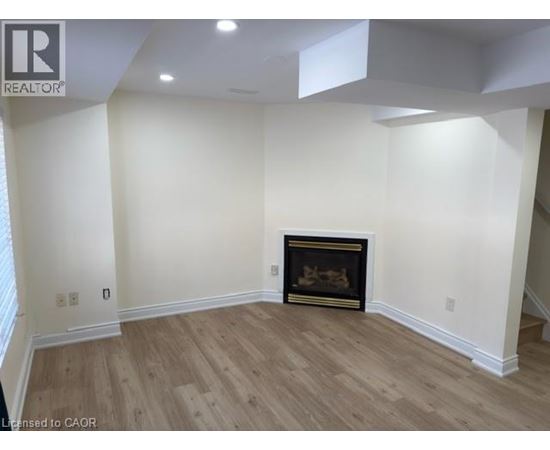 A living room with a fireplace and wood flooring.