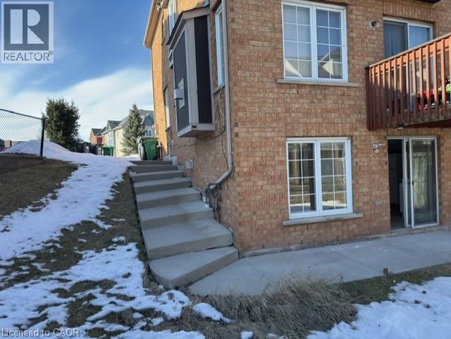A brick house with a realtor sign in the corner.