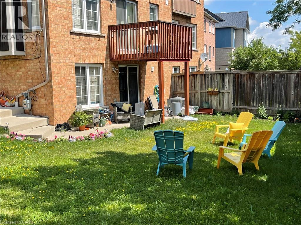 A patio with a table and chairs in front of a brick building.