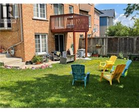 A patio with a table and chairs in front of a brick building.