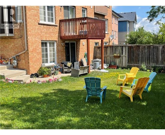 A patio with a table and chairs in front of a brick building.