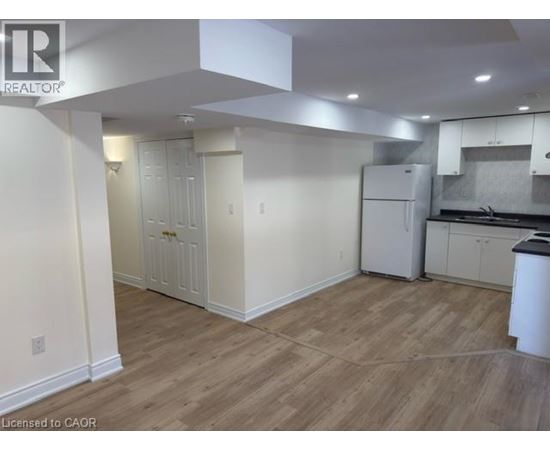 A kitchen area with white cabinets and a refrigerator.