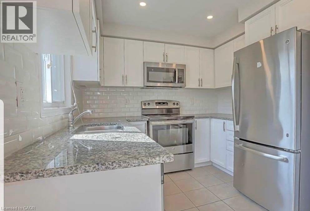 A modern kitchen with stainless steel appliances and white cabinets.