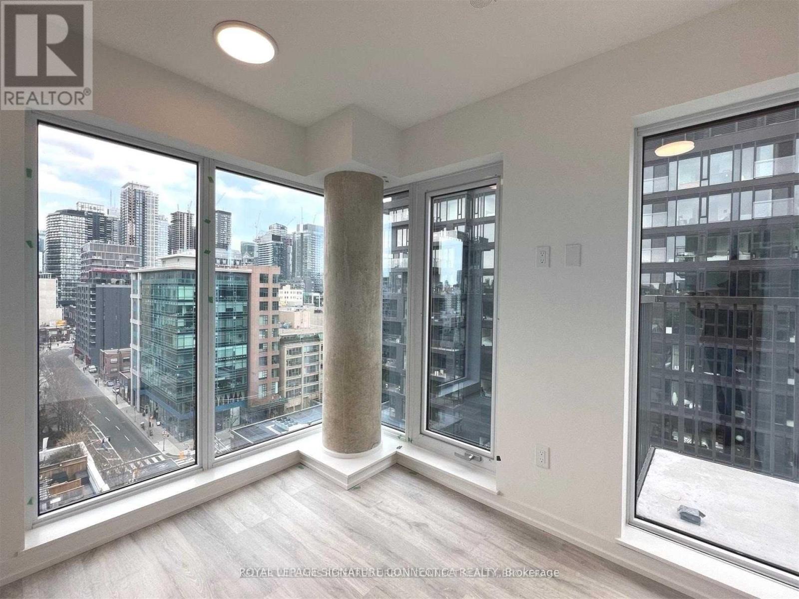 A room with a view of the cityscape through large windows.