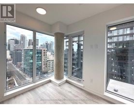 A room with a view of the cityscape through large windows.