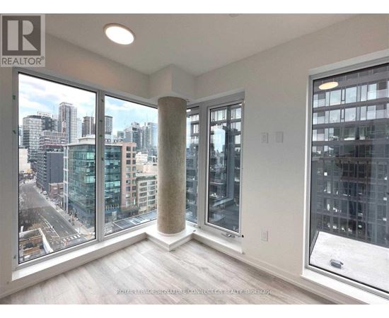 A room with a view of the cityscape through large windows.