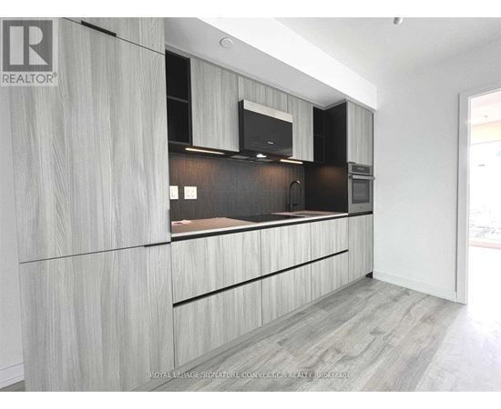 A modern kitchen with wooden cabinets and a black countertop.