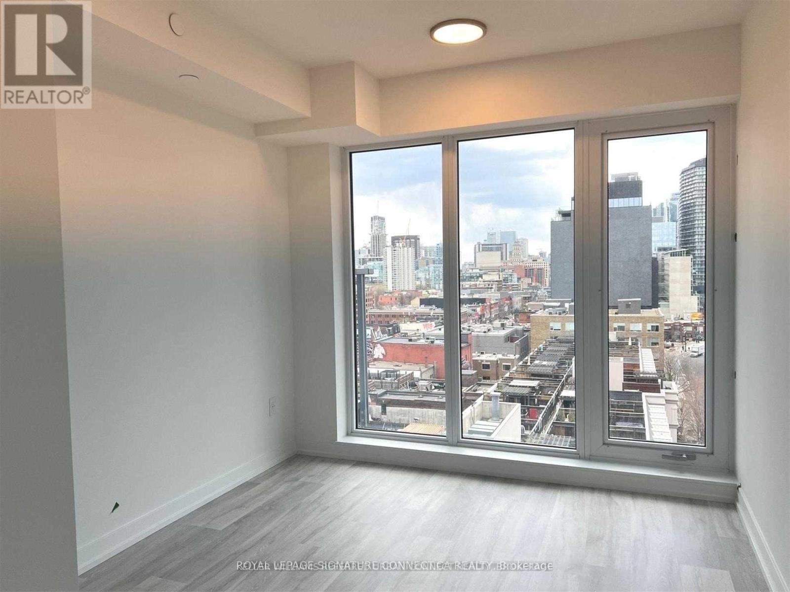 A realtor's image of an empty room with a view of the city.
