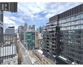 A city street with buildings on either side and a cloudy sky.