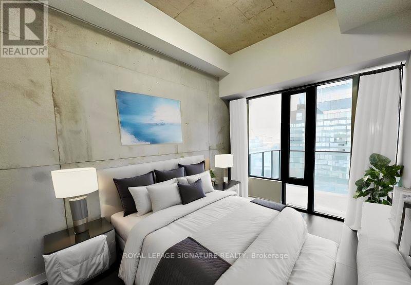 A bedroom with a large bed, a painting on the wall, and a plant on the windowsill.